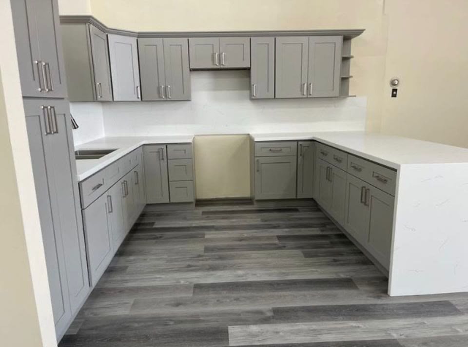 Completed gray U-shaped kitchen with hardwood floors